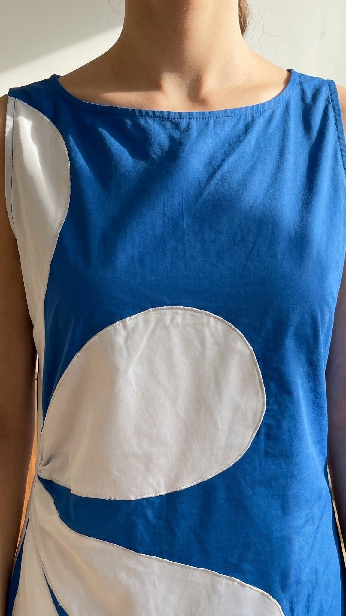 Blue and white sleeveless top worn by a person
