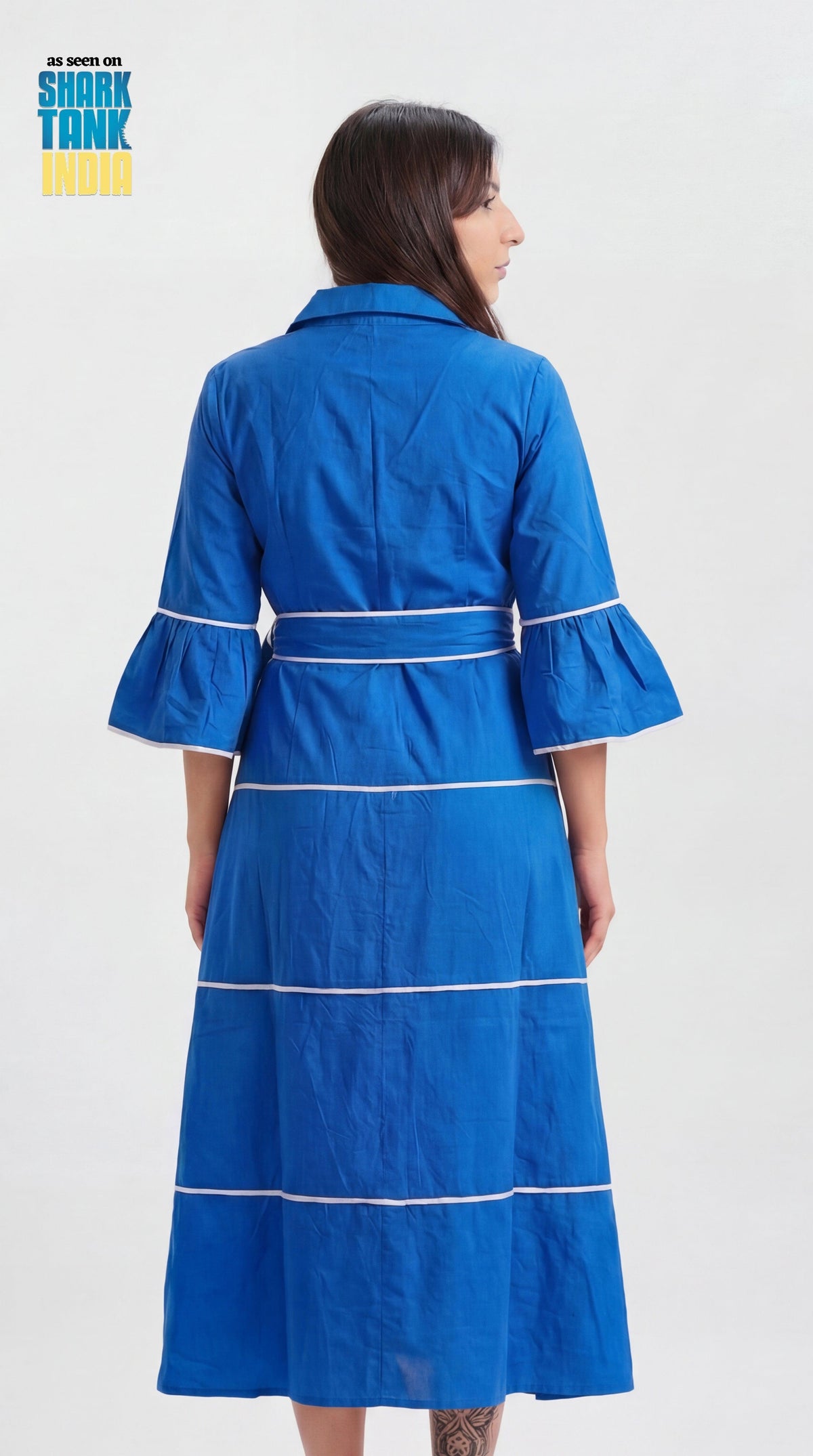 Woman wearing a blue dress with white trim on a white background