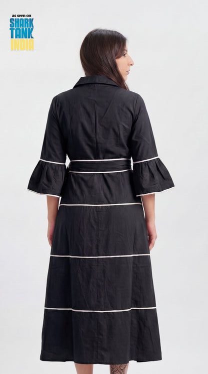 Woman wearing a black dress with white trim on a white background