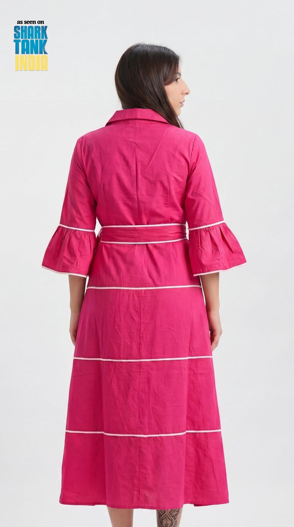 Woman wearing a pink dress with white stripes on a white background