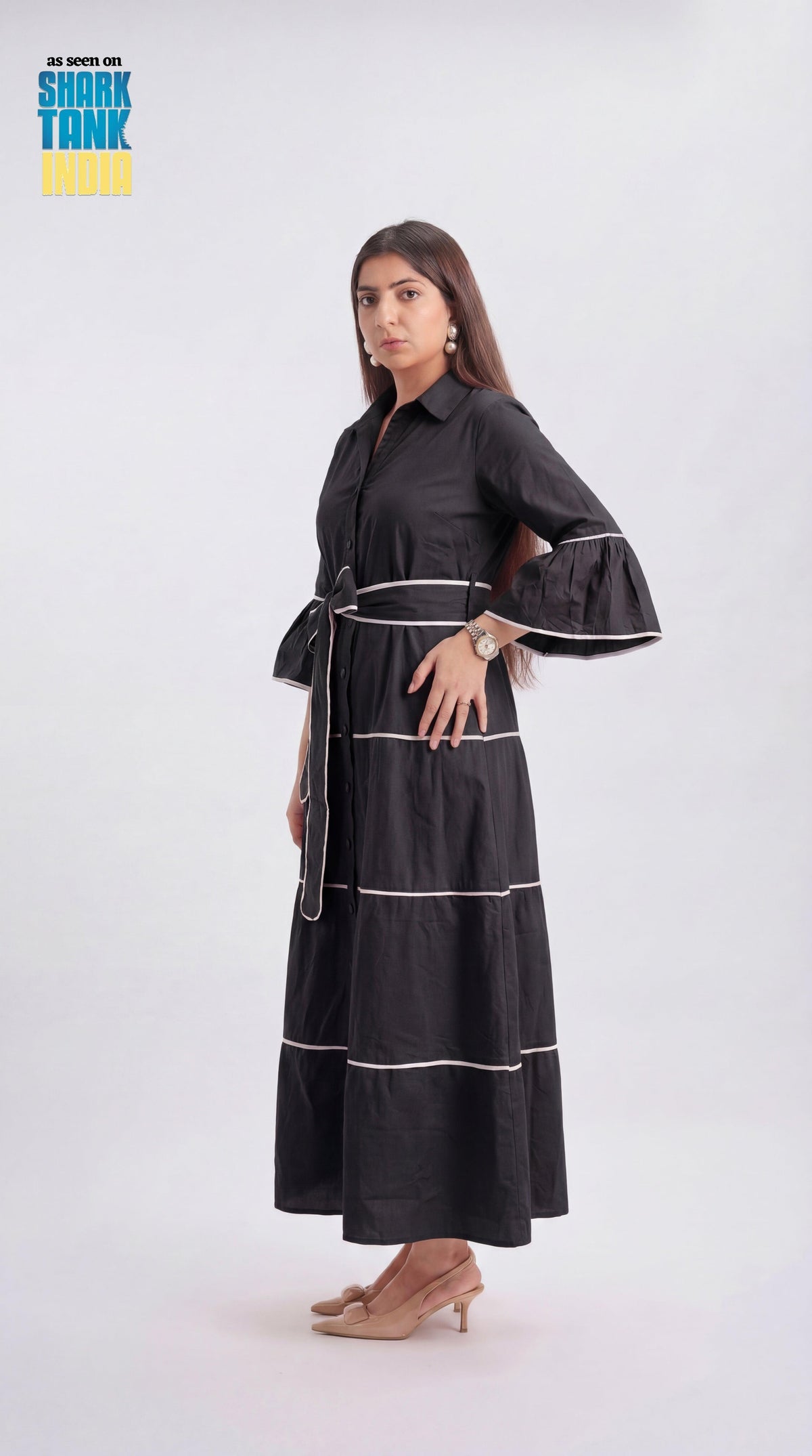 Woman wearing a black dress with white stripes on a white background