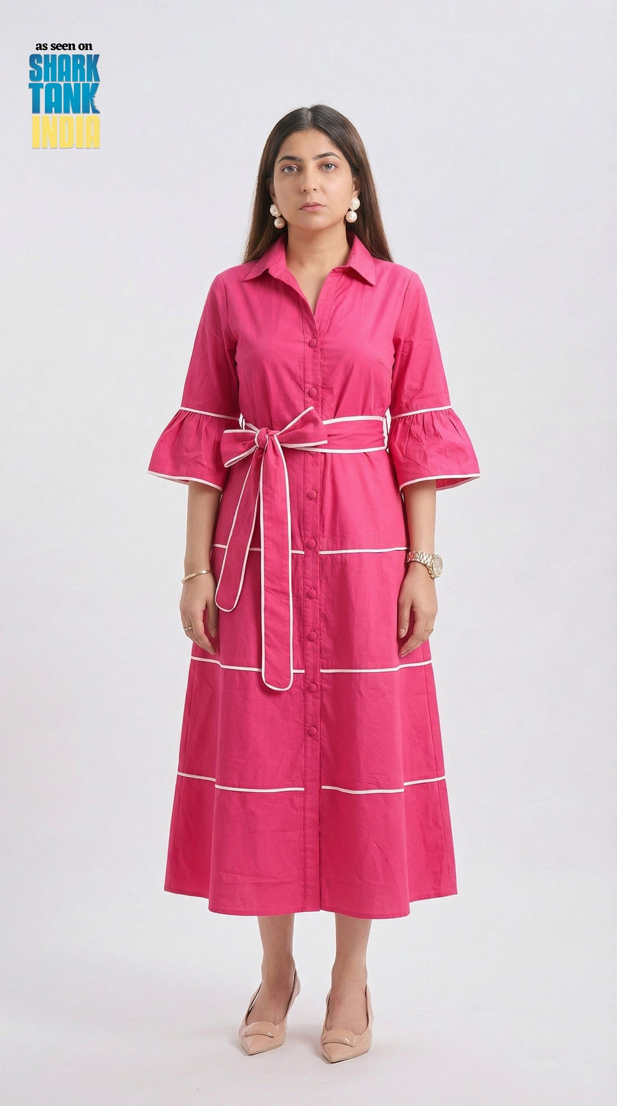 Woman wearing a pink dress with white accents on a white background