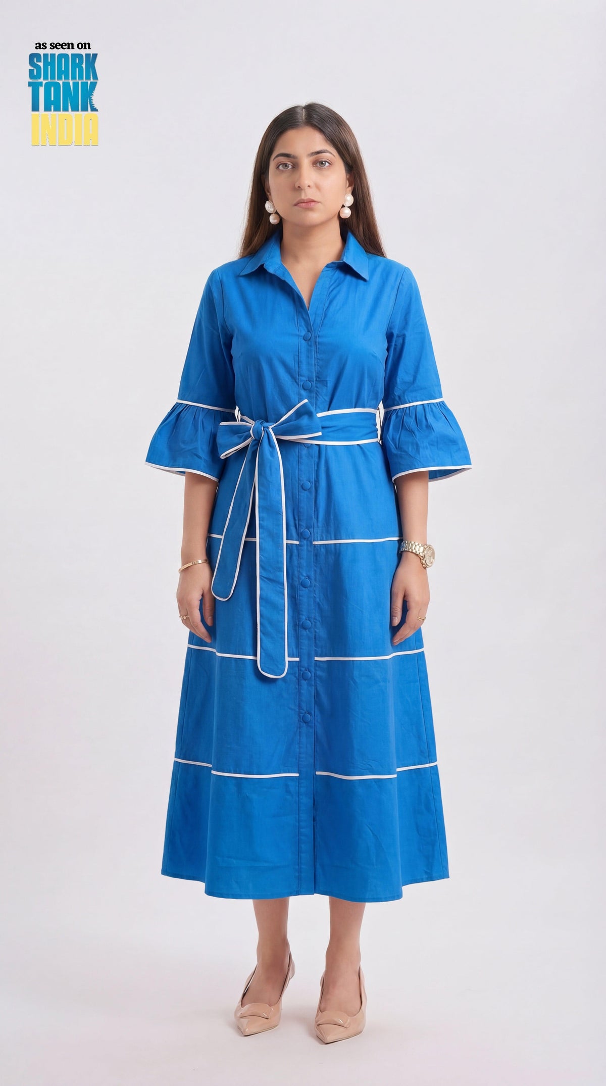 Woman wearing a blue dress with white accents on a white background