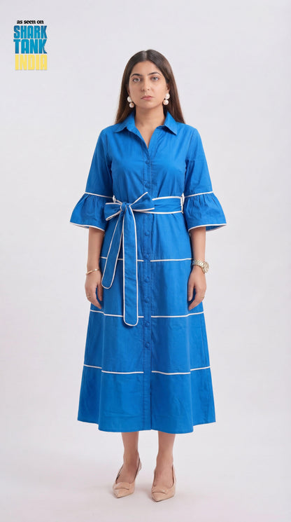 Woman wearing a blue dress with white accents on a white background