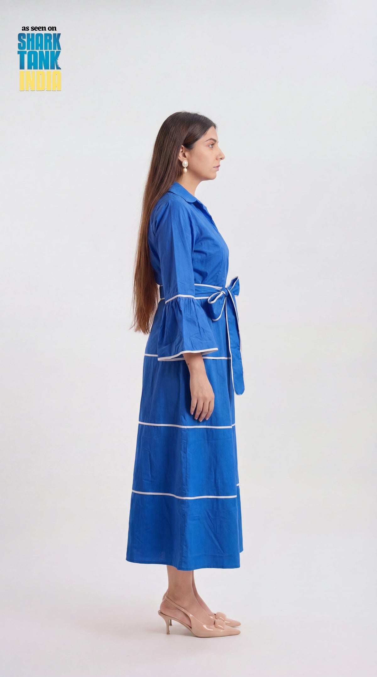 Woman wearing a blue dress with white stripes on a white background