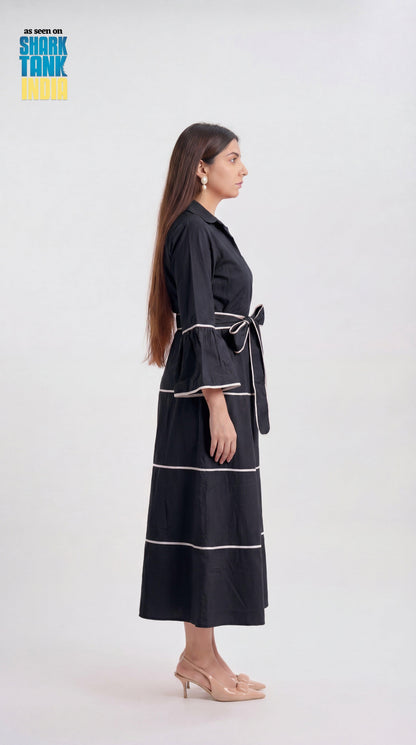 Woman wearing a black dress with white stripes on a white background