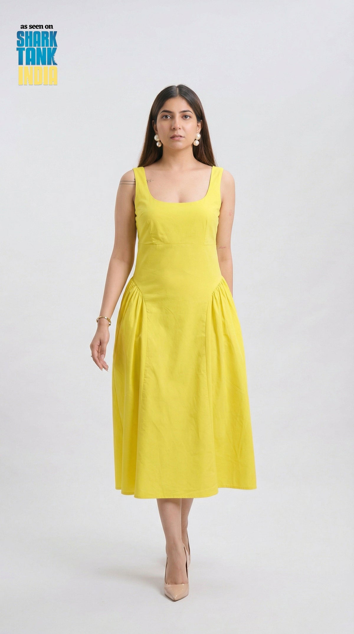 Woman wearing a yellow dress on a white background with 'Shark Tank' branding.