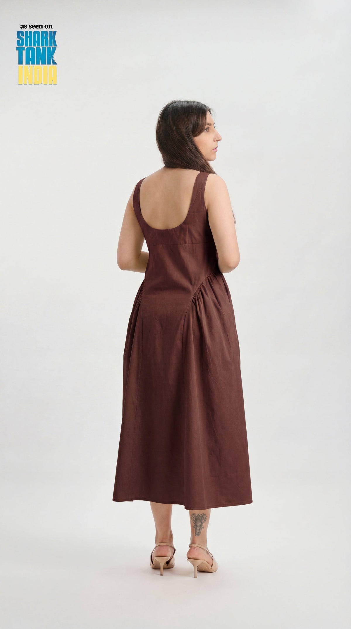 Woman wearing a brown dress on a white background with 'Shark Tank' branding.