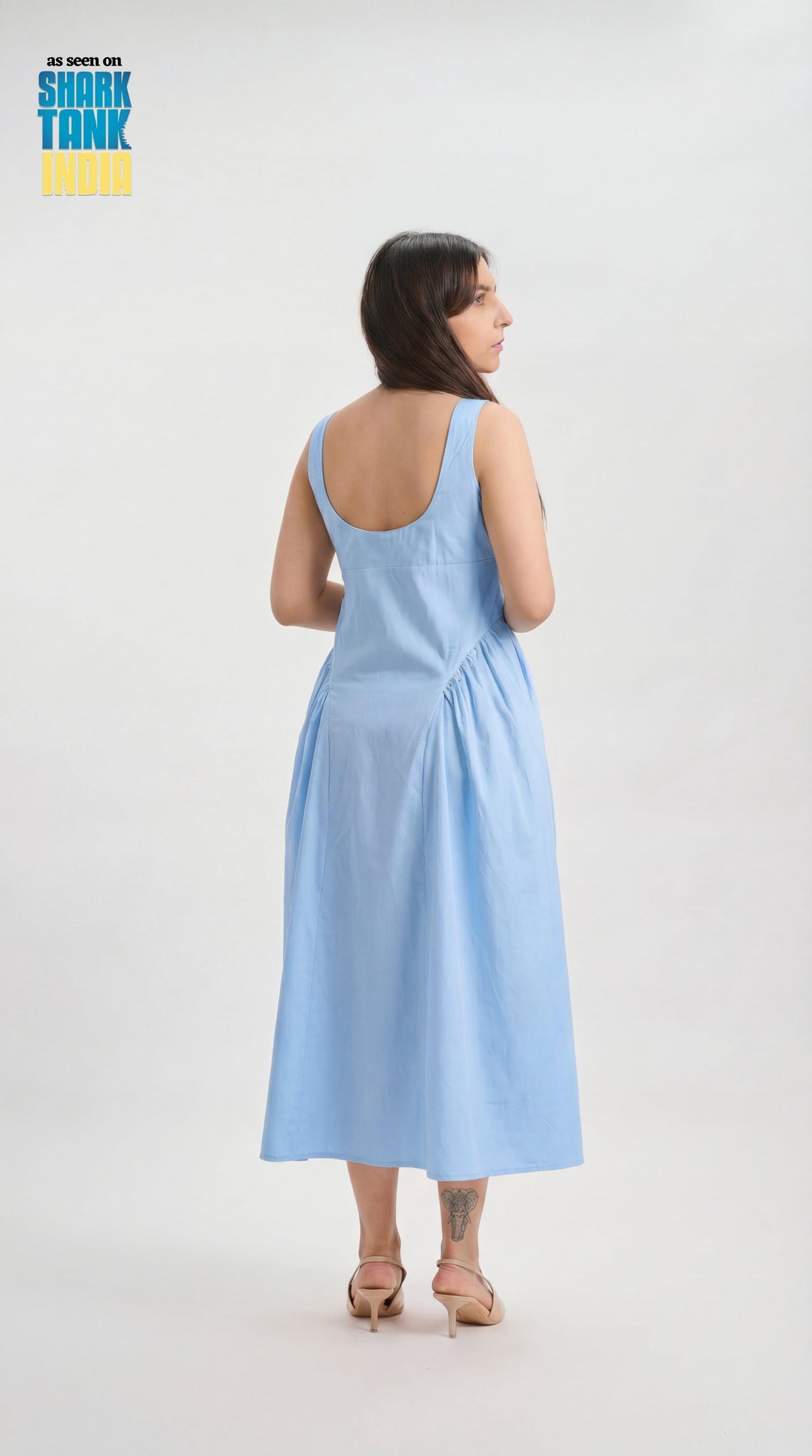 Woman wearing a light blue dress on a white background with 'Shark Tank' branding.
