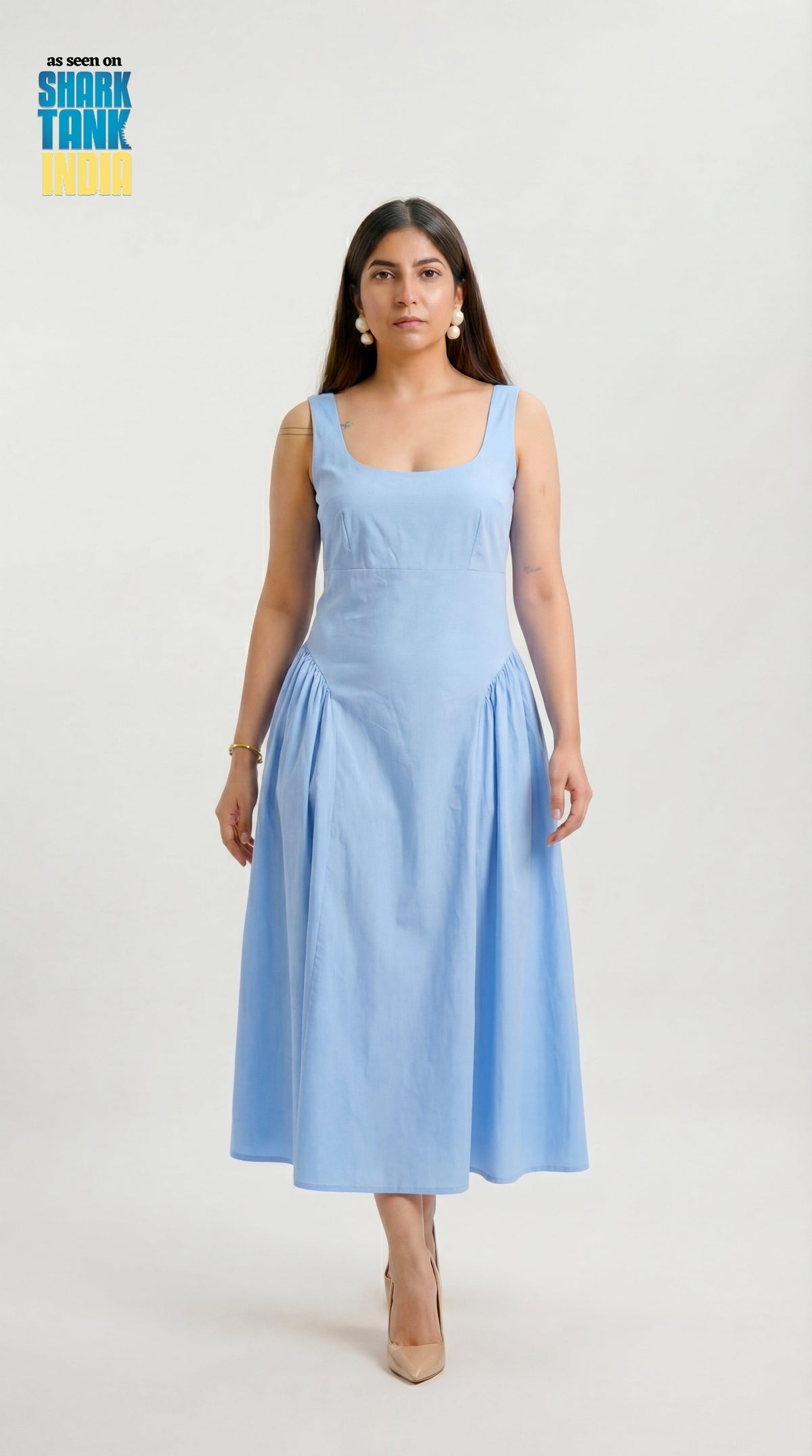 Woman wearing a light blue dress on a white background with Shark Tank logo.