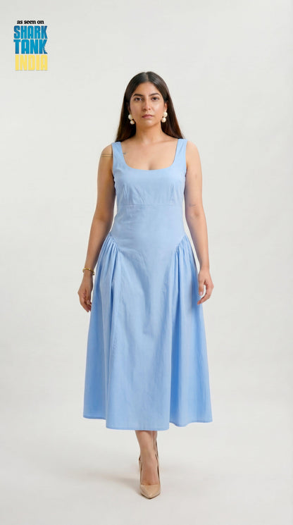 Woman wearing a light blue dress on a white background with Shark Tank logo.