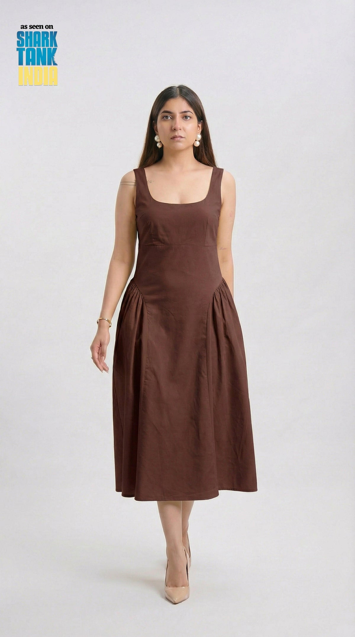 Woman wearing a brown dress on a white background with 'Shark Tank' logo.