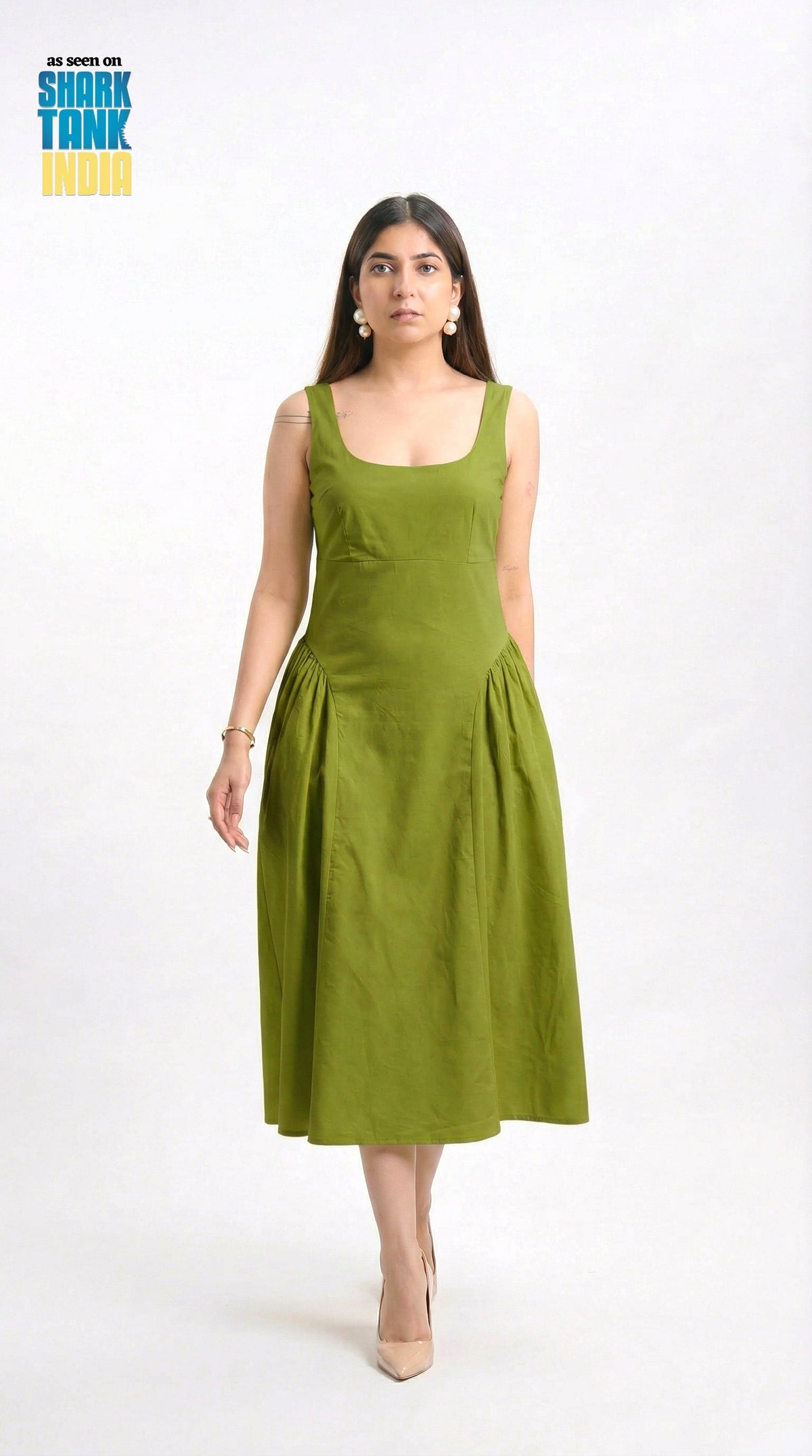 Woman wearing a green dress on a white background with 'Shark Tank India' logo.