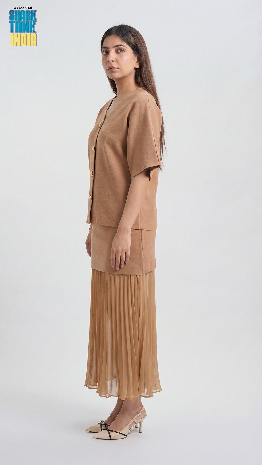 Woman wearing a beige outfit with a pleated skirt on a white background