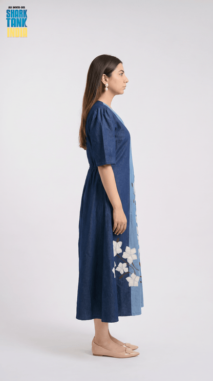 Woman wearing a blue dress with floral patterns on a white background