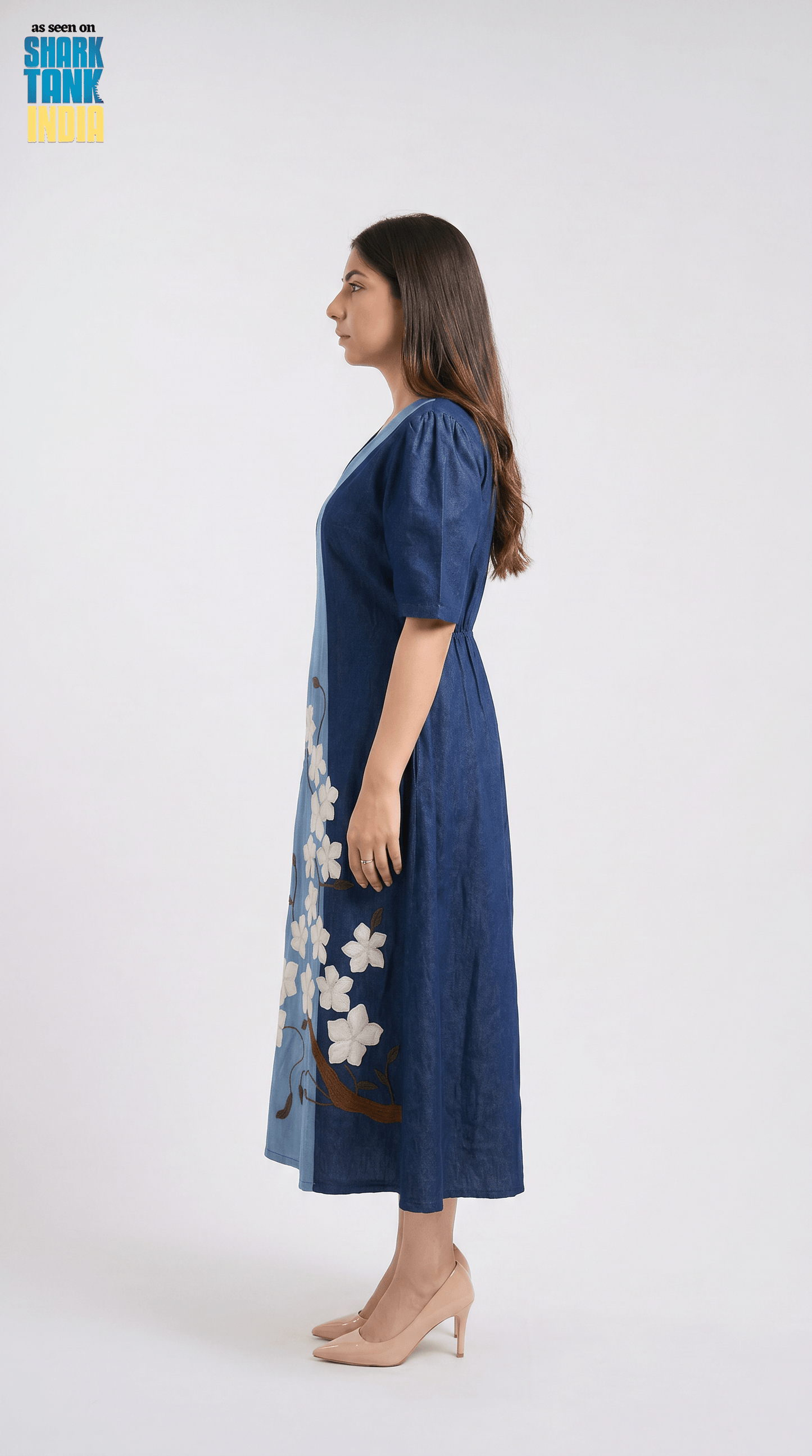 Woman wearing a blue dress with floral patterns on a white background