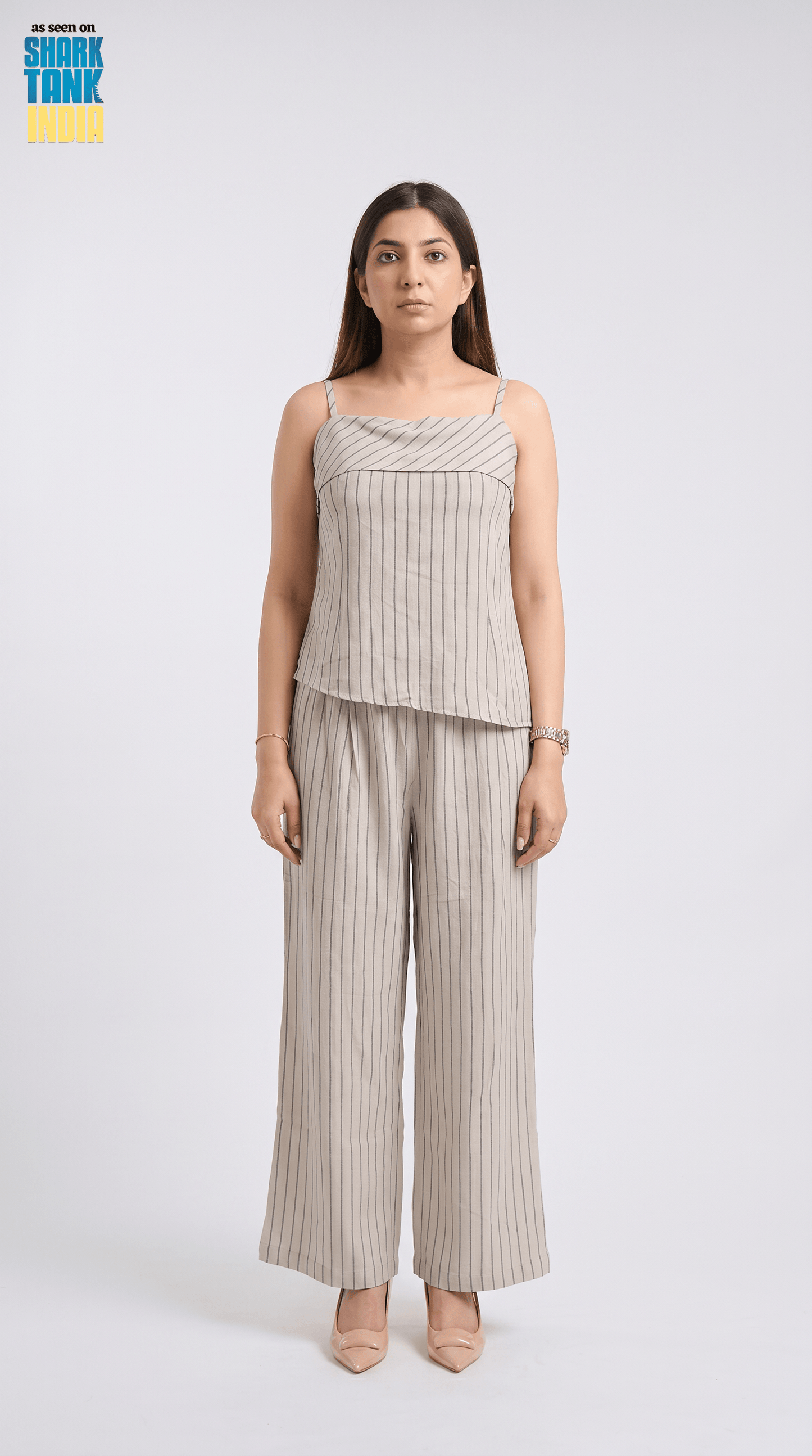 Woman wearing a striped top and wide-leg pants on a white background