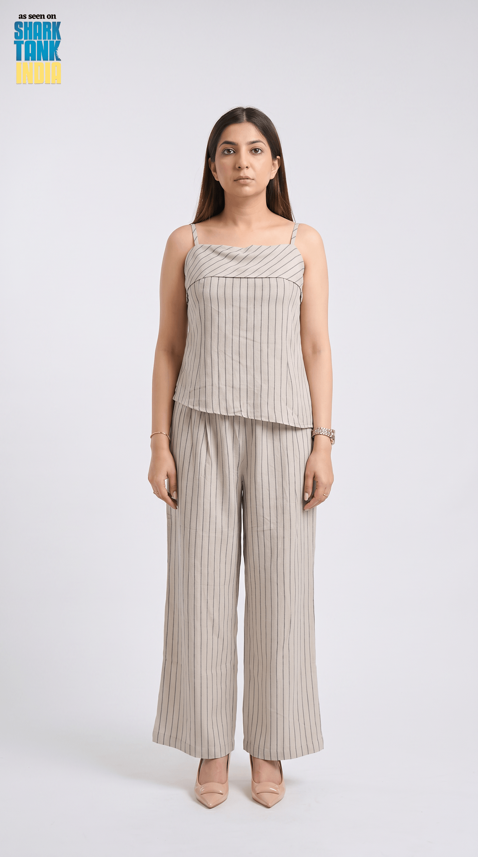 Woman wearing a striped top and wide-leg pants on a white background