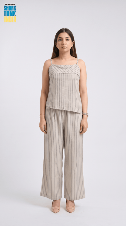 Woman wearing a striped top and wide-leg pants on a white background