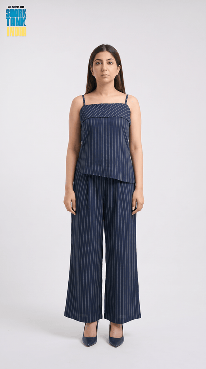 Woman wearing a navy striped jumpsuit on a white background