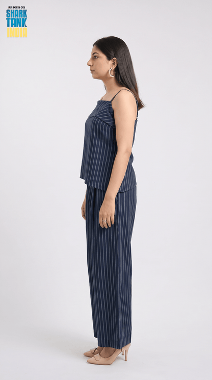 Woman wearing a navy pinstripe outfit on a white background