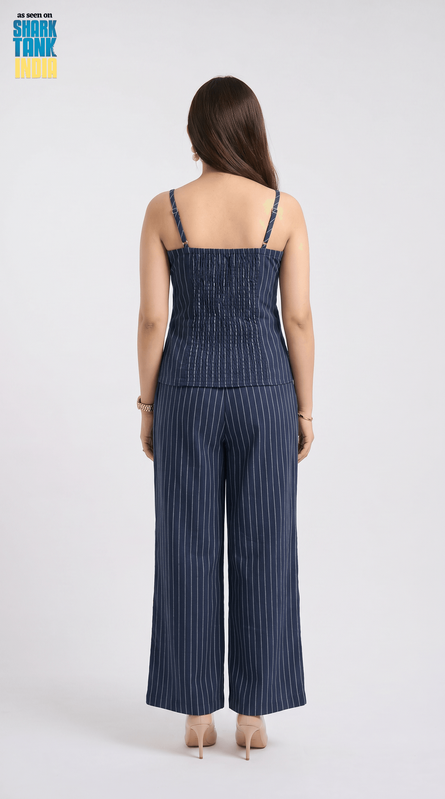 Woman wearing a blue pinstripe jumpsuit on a white background with 'Shark Tank' logo.
