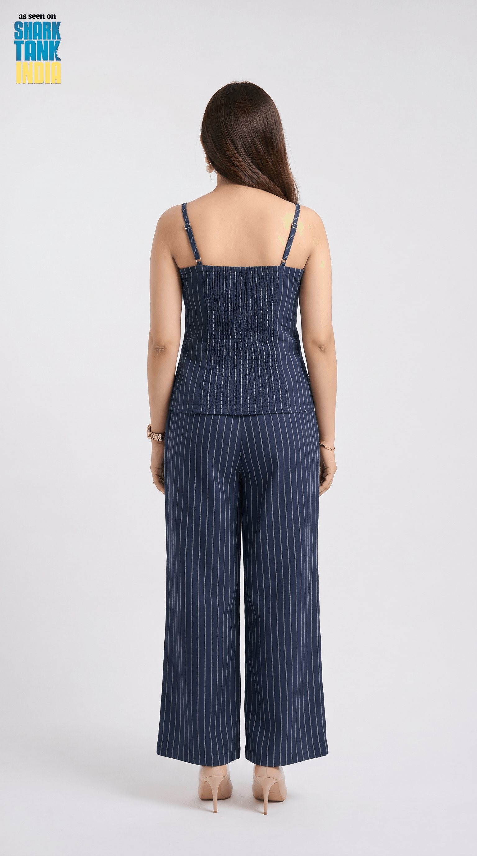 Woman wearing a blue pinstripe jumpsuit on a white background with 'Shark Tank' logo.