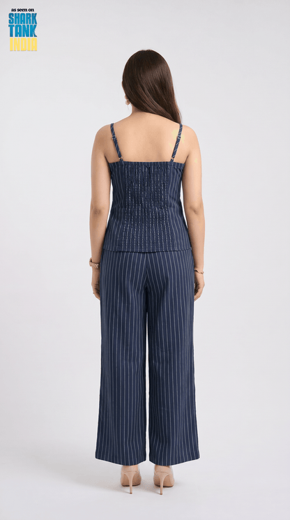 Woman wearing a blue pinstripe jumpsuit on a white background with 'Shark Tank' logo.