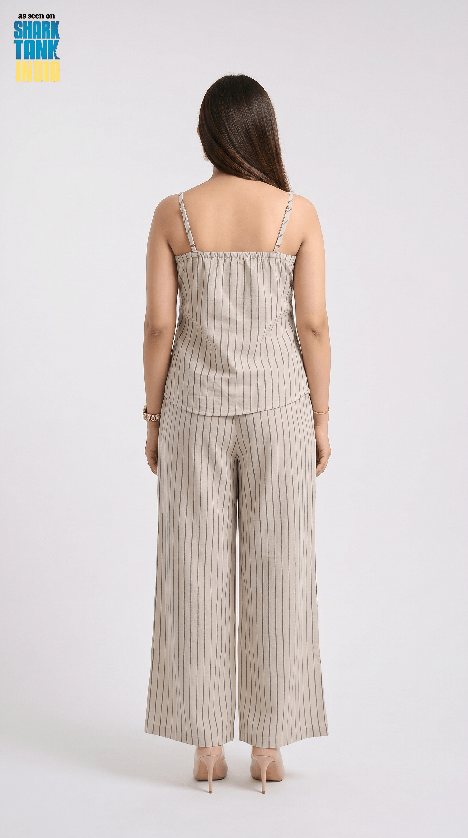 Woman wearing a beige striped jumpsuit on a white background