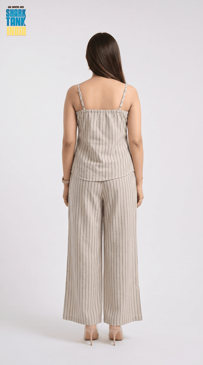 Woman wearing a beige striped jumpsuit on a white background