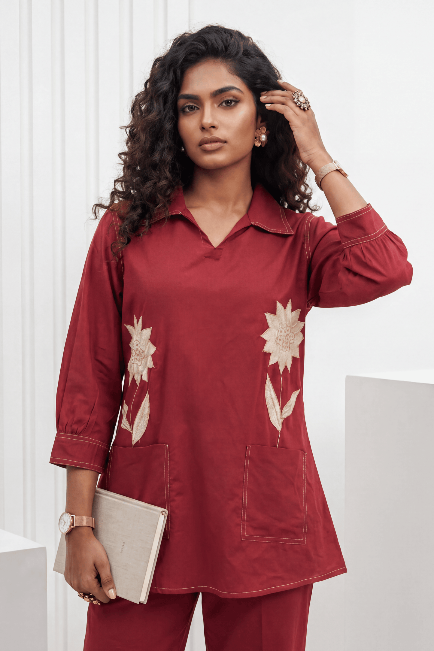 Woman wearing a red outfit with floral patterns against a white background