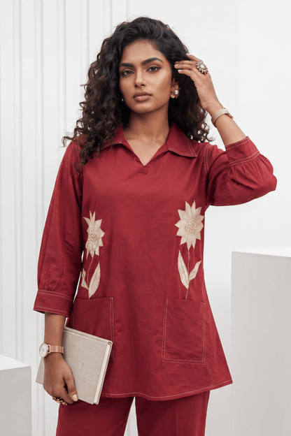 Woman wearing a red outfit with floral patterns against a white background