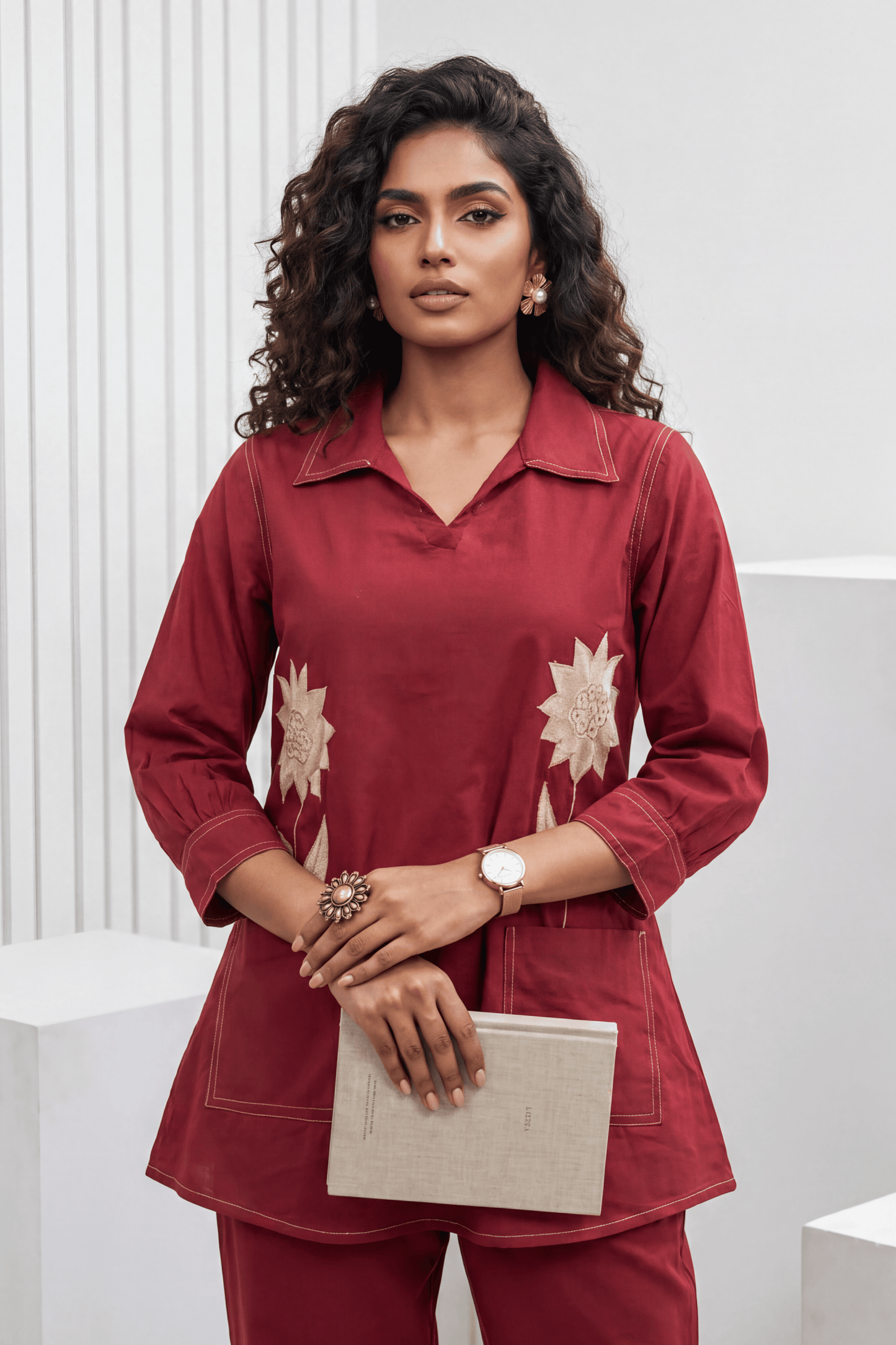 Woman wearing a red outfit with floral patterns against a white background
