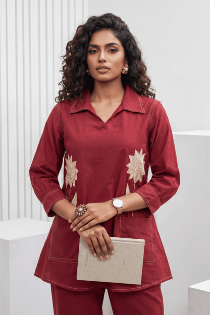 Woman wearing a red outfit with floral patterns against a white background