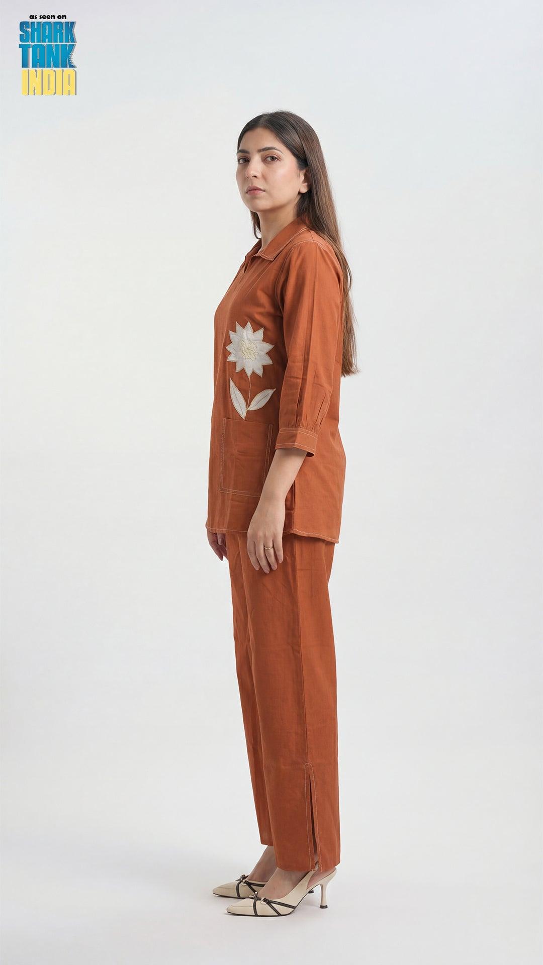 Woman wearing a brown outfit with a floral design on a white background