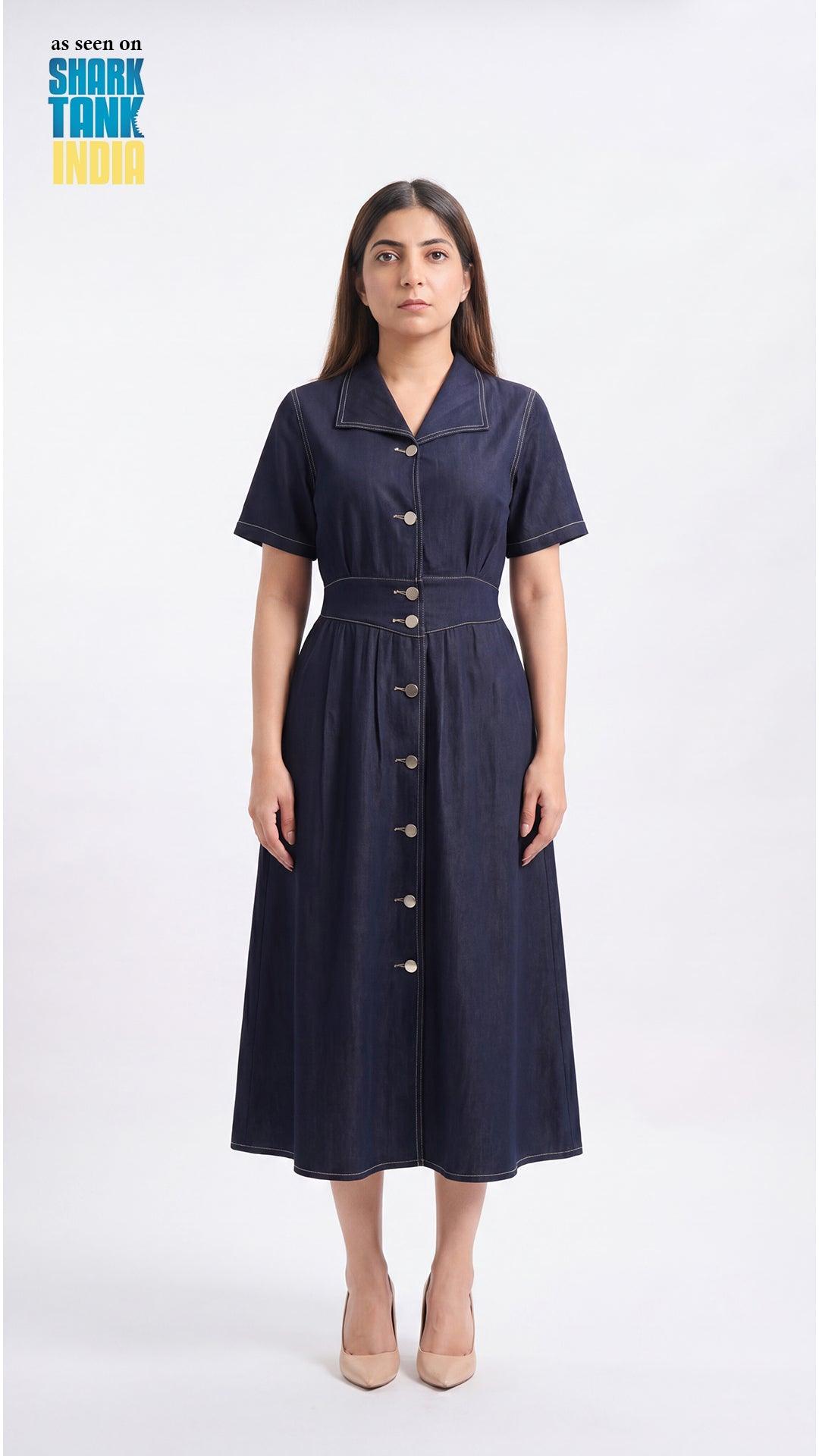 Woman wearing a navy dress with buttons on a white background