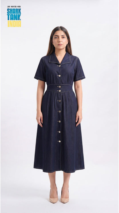 Woman wearing a navy dress with buttons on a white background
