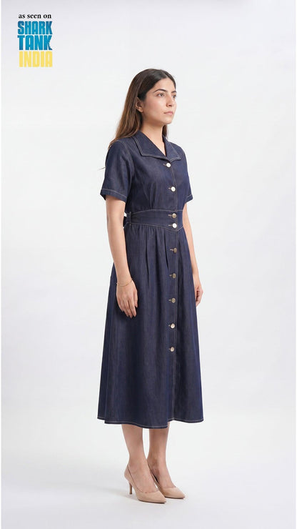 Woman wearing a navy dress with buttons on a white background