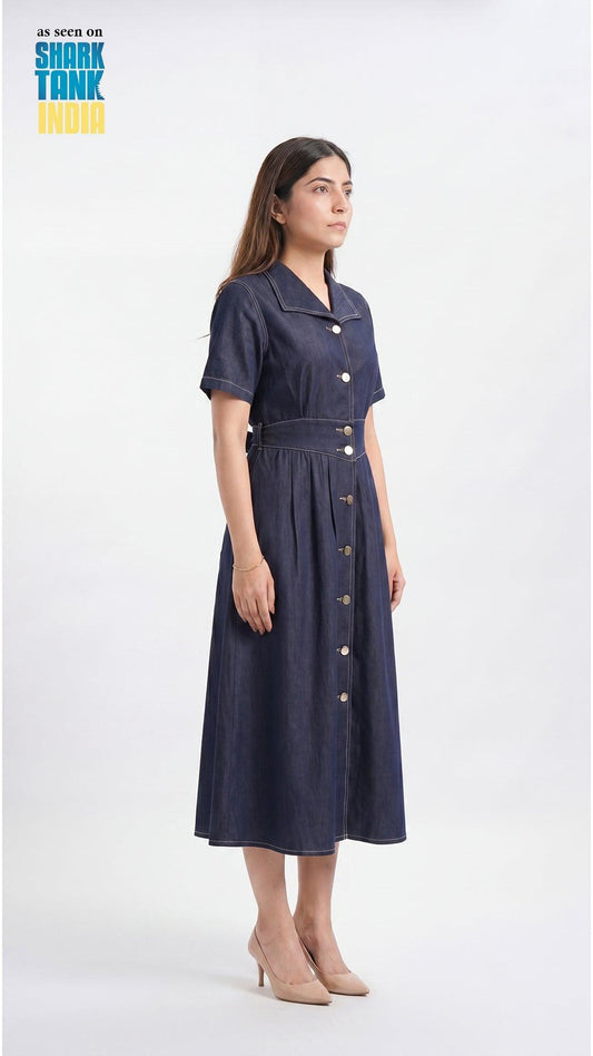 Woman wearing a navy dress with buttons on a white background