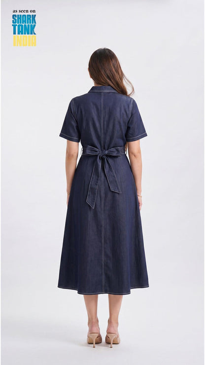 Woman wearing a navy blue dress with a belt on a white background