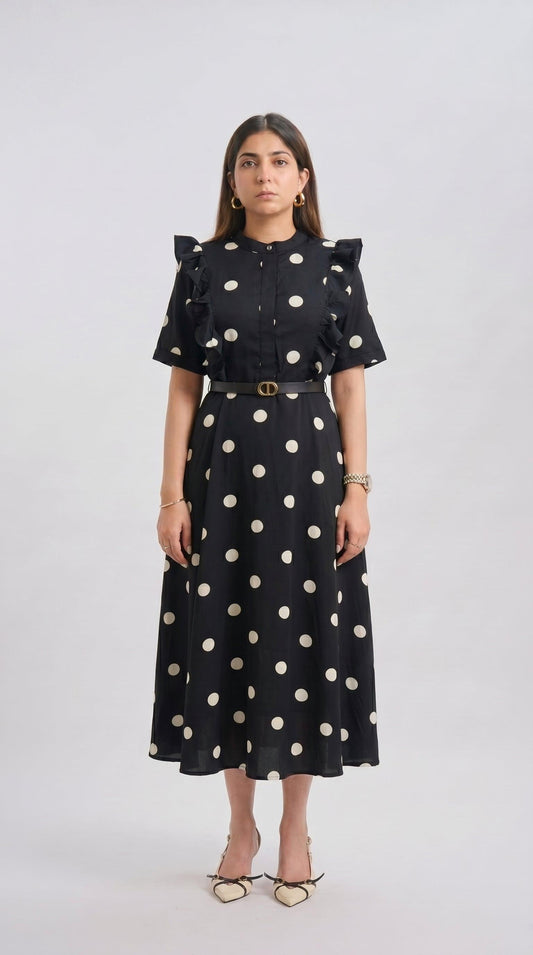 Woman wearing a black dress with white polka dots on a white background