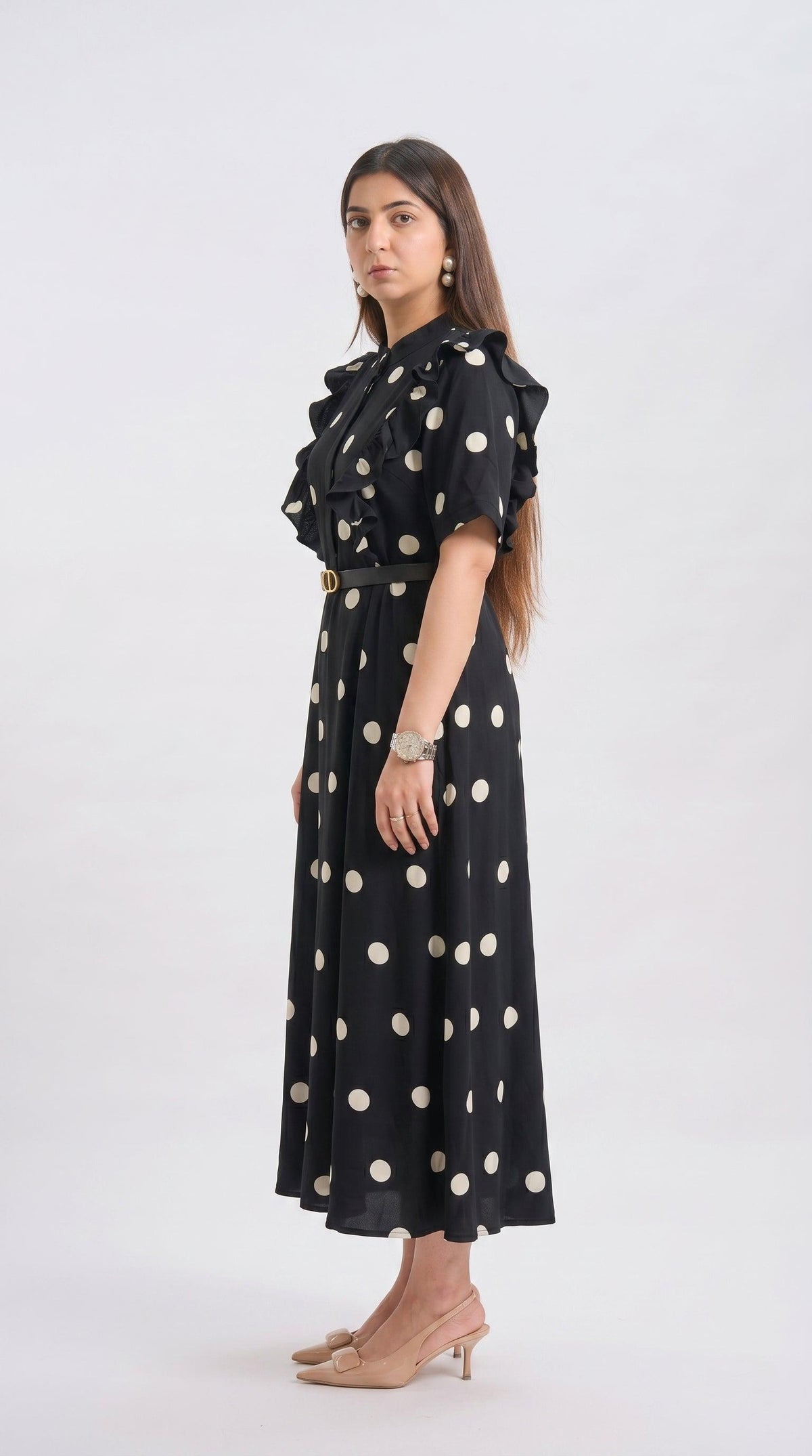 Woman wearing a black dress with white polka dots on a white background