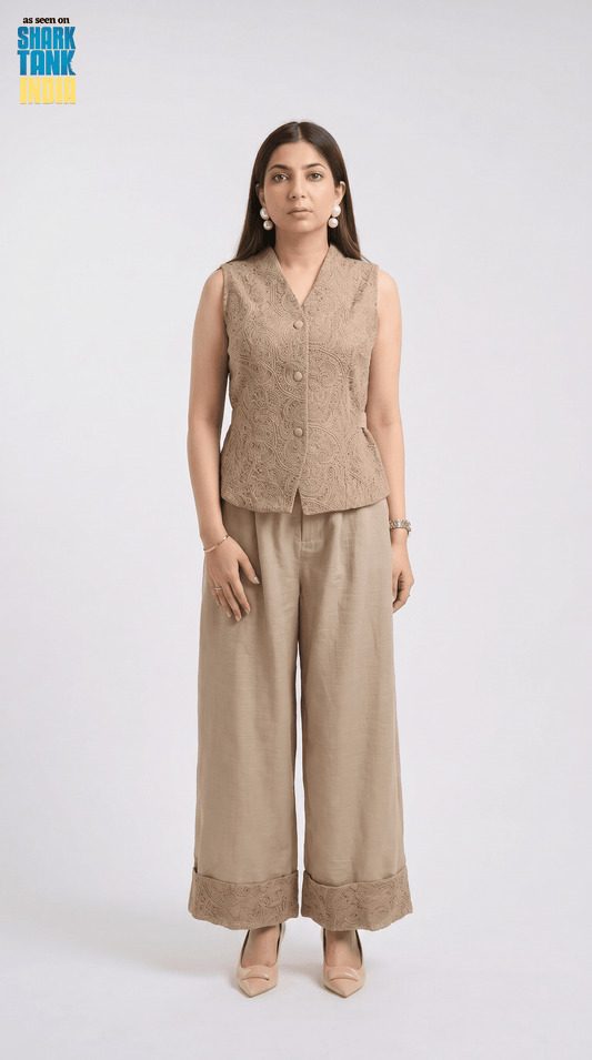 Woman wearing a beige sleeveless top and wide-leg pants on a white background