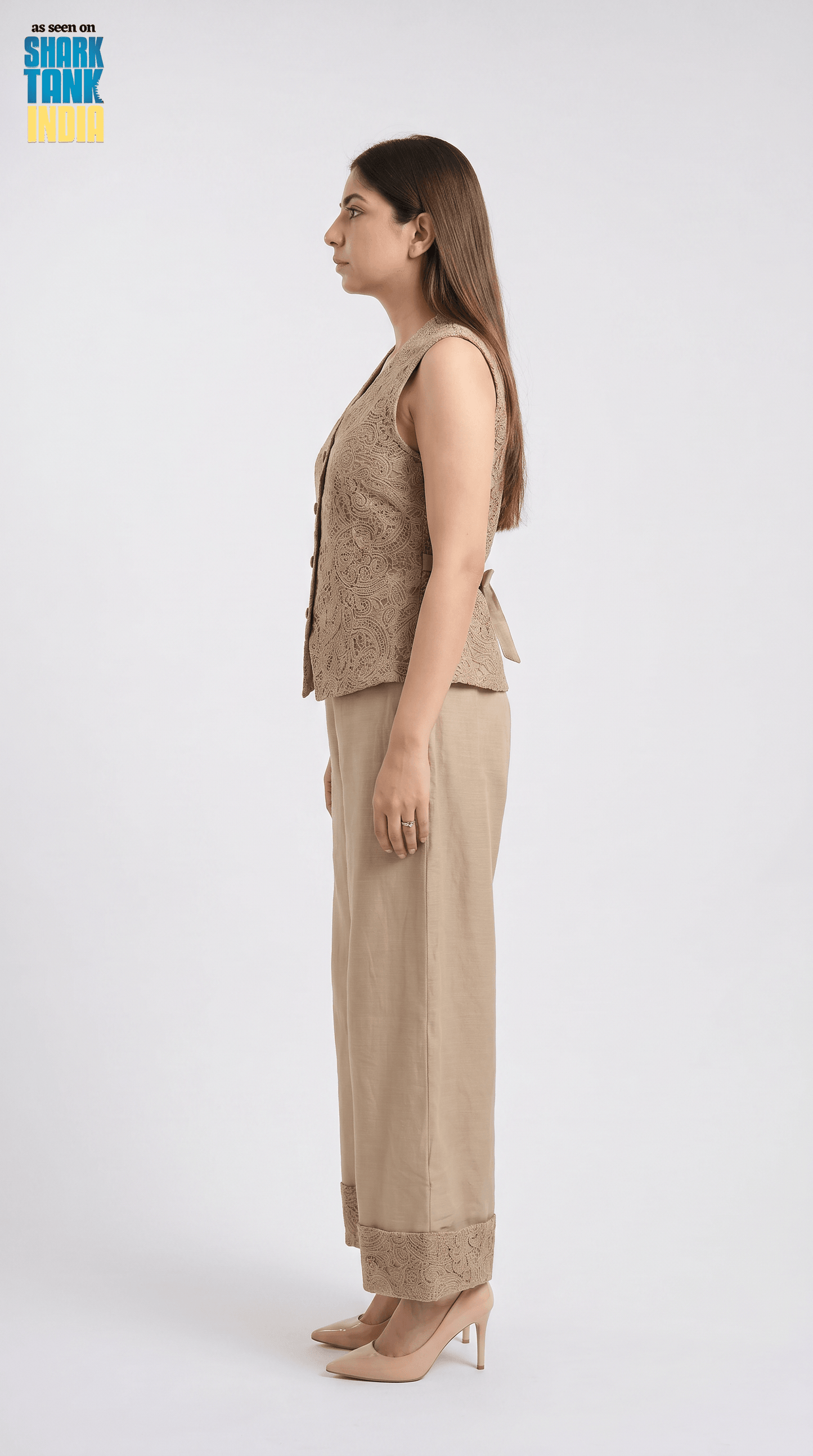 Woman wearing a beige sleeveless top and pants on a white background