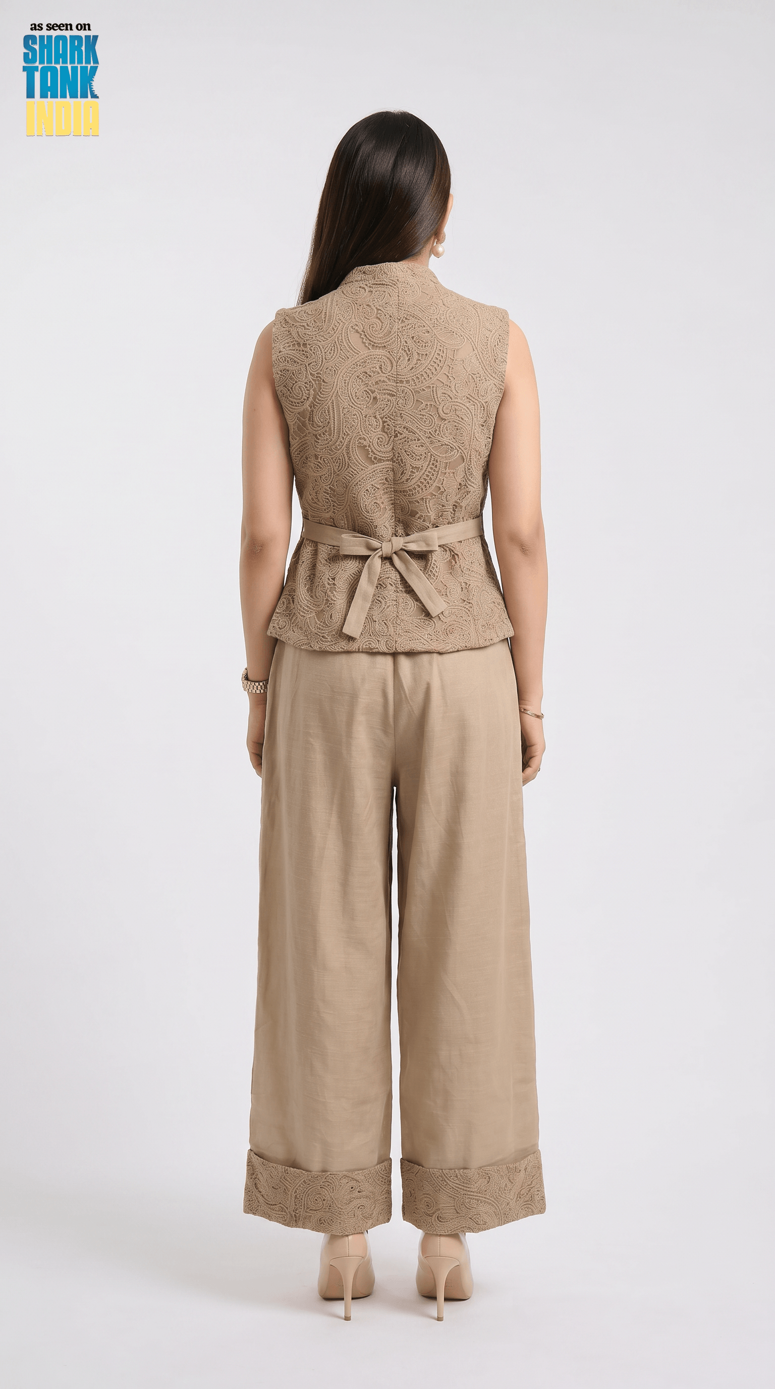 Woman wearing a beige sleeveless top and wide-leg pants on a white background
