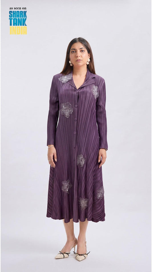 Woman wearing a purple dress with floral patterns on a white background