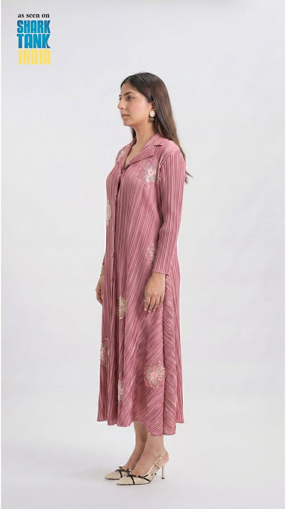 Woman wearing a pink striped dress with floral patterns on a white background