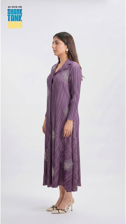 Woman wearing a long purple dress with a pattern on a white background