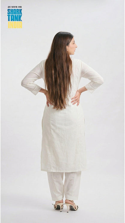 Woman wearing a white outfit on a plain background