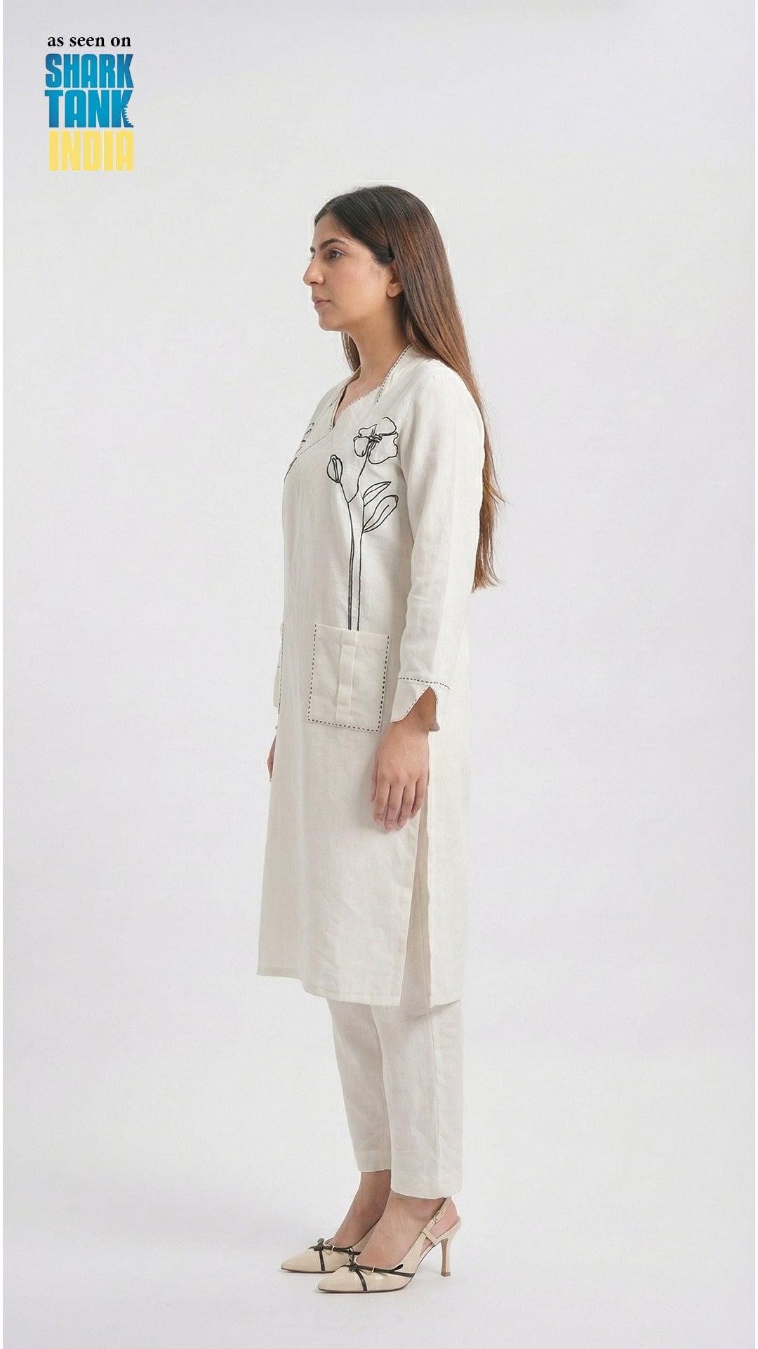 Woman wearing a white outfit with a floral design on a white background